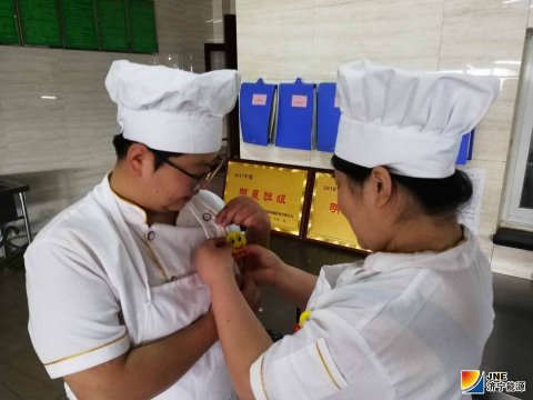 安居煤礦食堂職工佩戴“笑臉牌”上崗